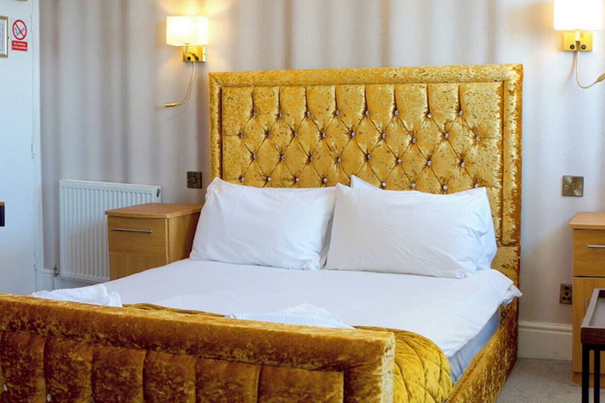 A bed with a tufted headboard, white bedding, and two bedside tables.