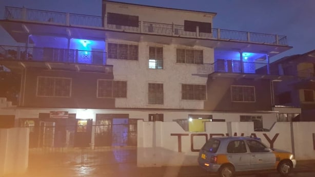 A multi-story building with balconies and a gated entrance. - Topway Hotel (Nkawkaw)