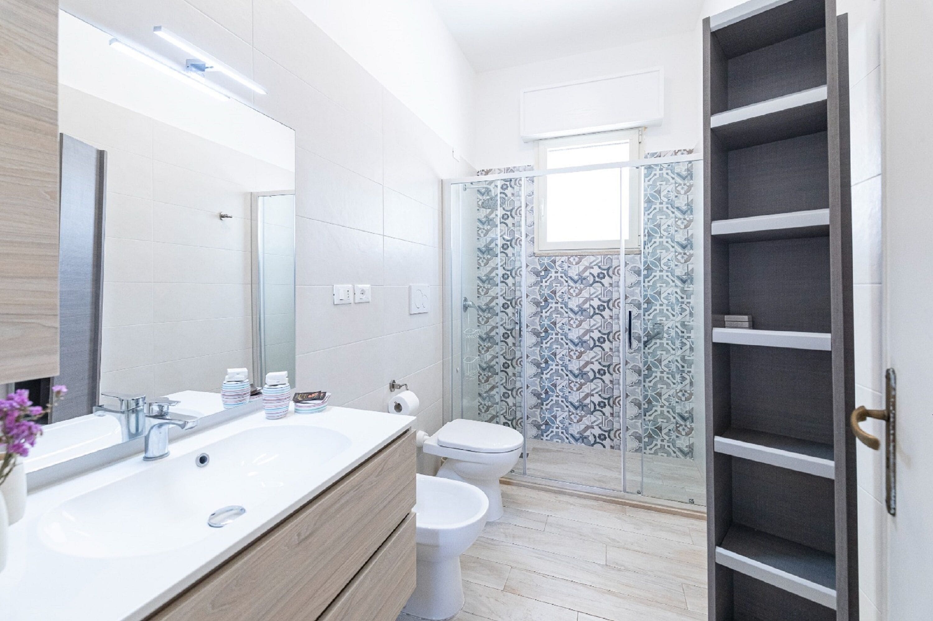 Ein modernes Badezimmer mit großem Waschbecken, Toilette und Duschbereich.