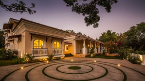 A large, two-story house with a well-maintained garden and a circular driveway. - Maravilha a boutique stay (Assagao)