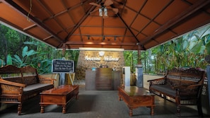 A reception area with a stone wall, wooden furniture, and a sign reading 'Amarine Wellness'.