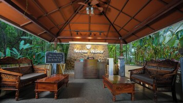 Un área de recepción con pared de piedra, muebles de madera y un letrero que dice 'Amarine Wellness'.