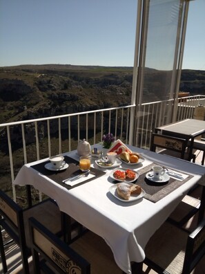 Ein Tisch ist für das Frühstück gedeckt, mit Blick auf ein Tal.