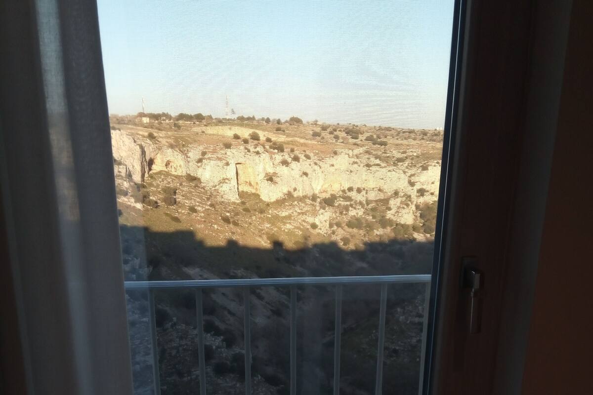 A room with a large window overlooking a barren landscape.
