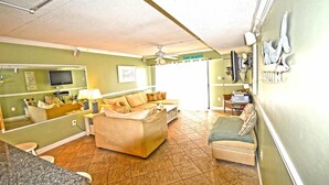 Un espacio habitable compacto con un sofá, un televisor y una zona de comedor.