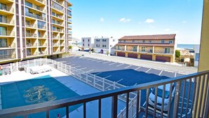 Un hotel con piscina, estacionamiento y vista al océano.