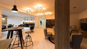 A modern interior with a wooden dining area, bar stools, and a fireplace. - Hotel Onyarbi (Hondarribia)