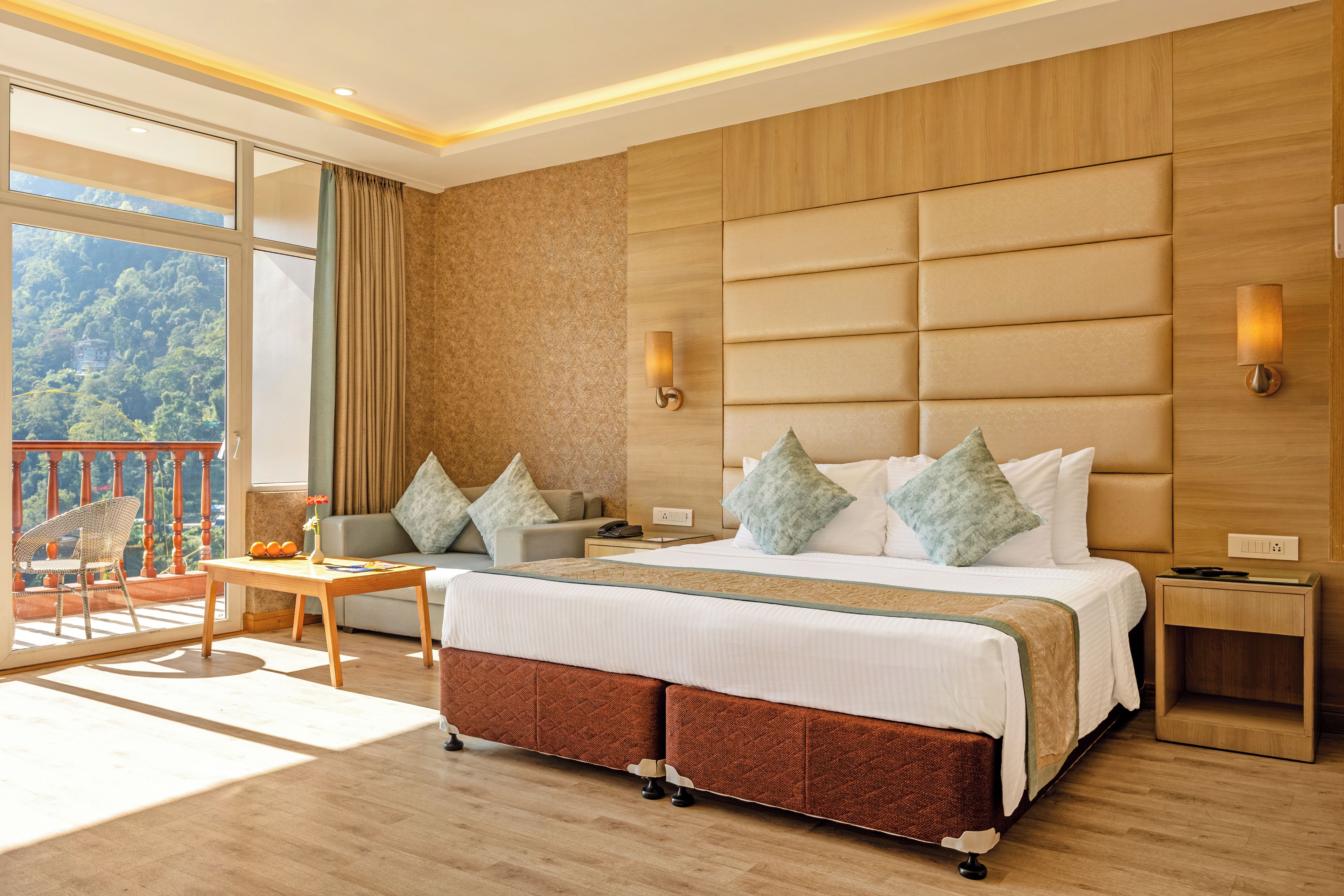 Ein Hotelzimmer mit einem großen Bett, einem Balkon und Blick sowie einem Holzkopfteil.