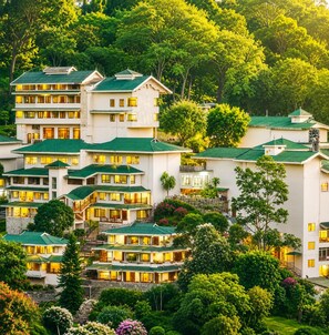 Ein mehrstöckiges Hotel mit Gründach, umgeben von üppiger Vegetation und Bäumen.
