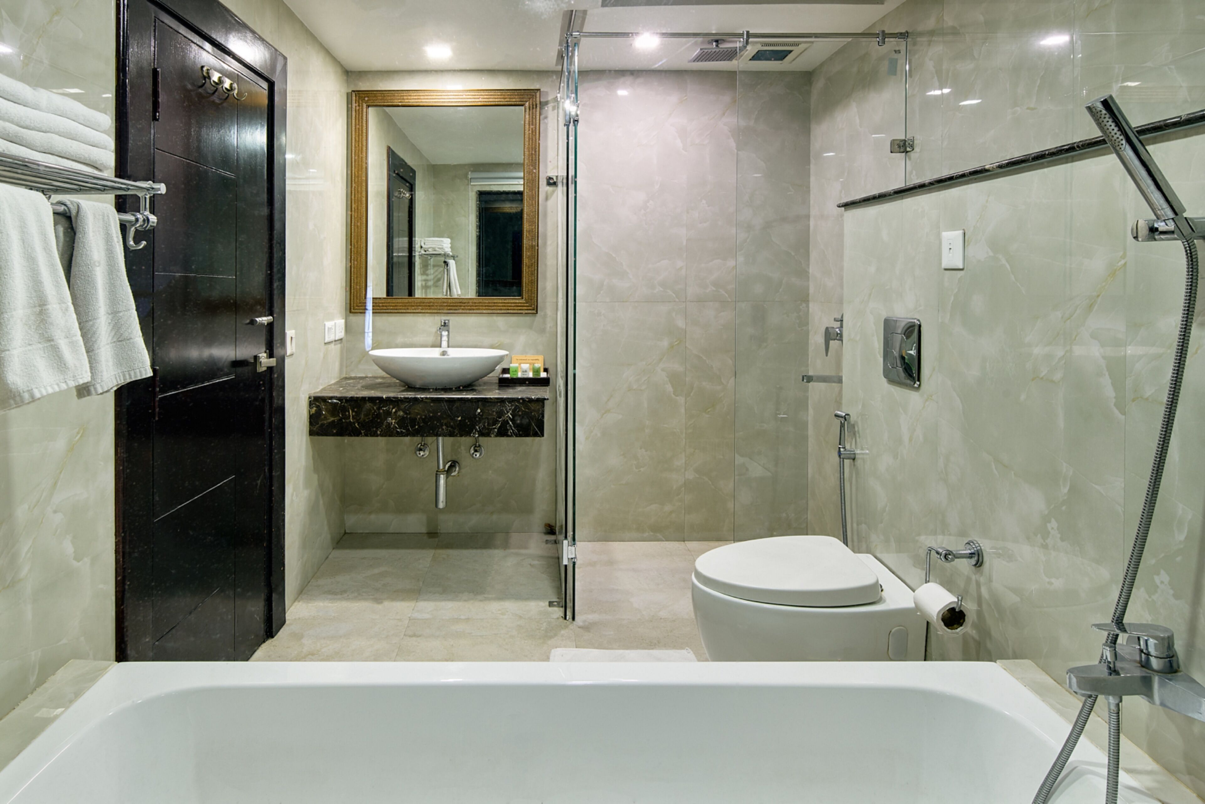 A modern bathroom with a bathtub, toilet, and sink.