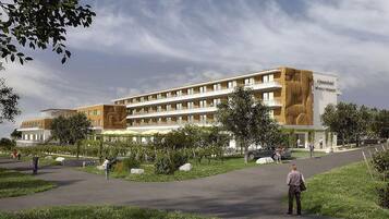 Stunning hotel with a flat roof and symmetrical facade, surrounded by lush greenery and a covered outdoor area.
