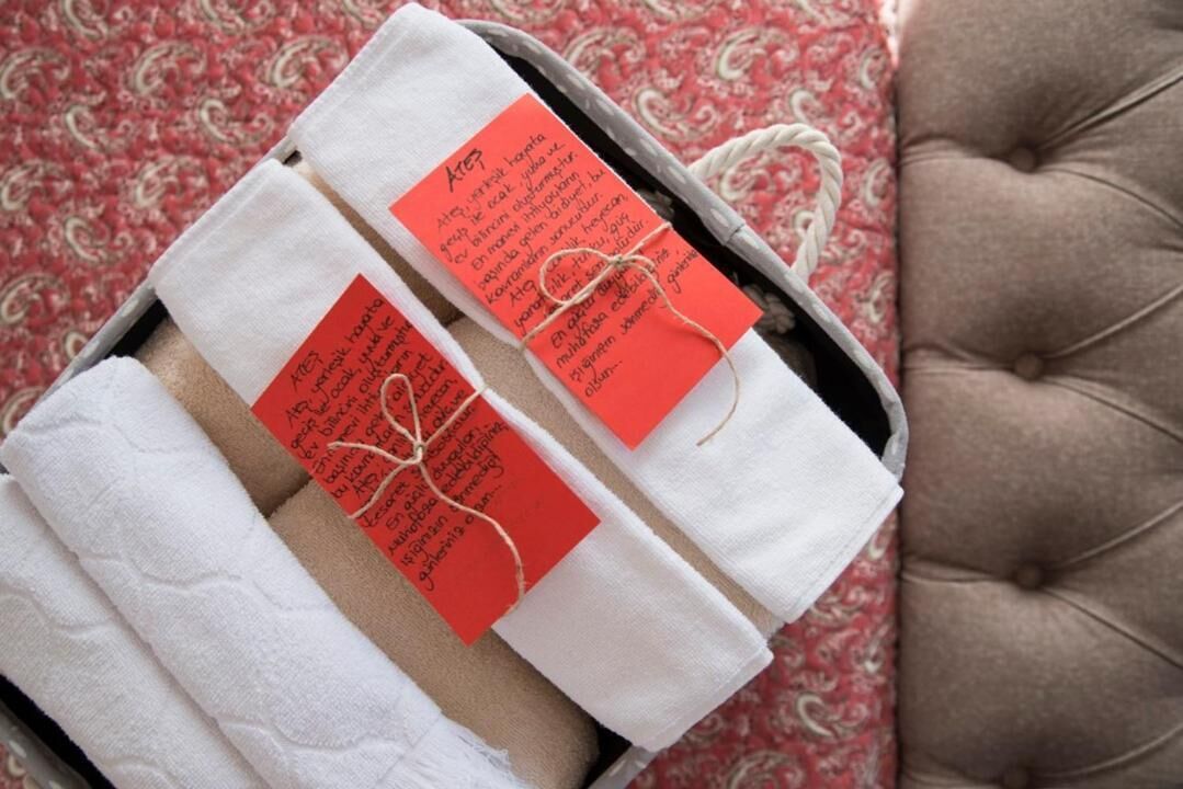 Une boîte contenant des serviettes pliées, chacune munie d’une étiquette rouge.