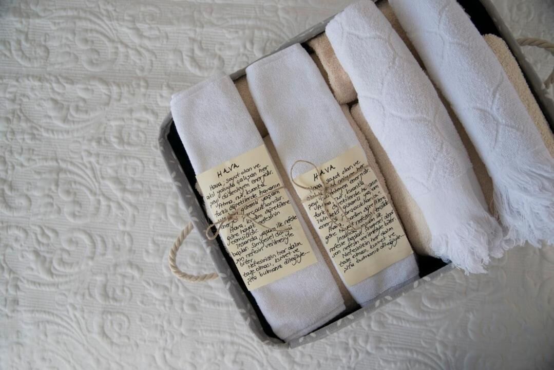 A box containing rolled towels with handwritten notes.