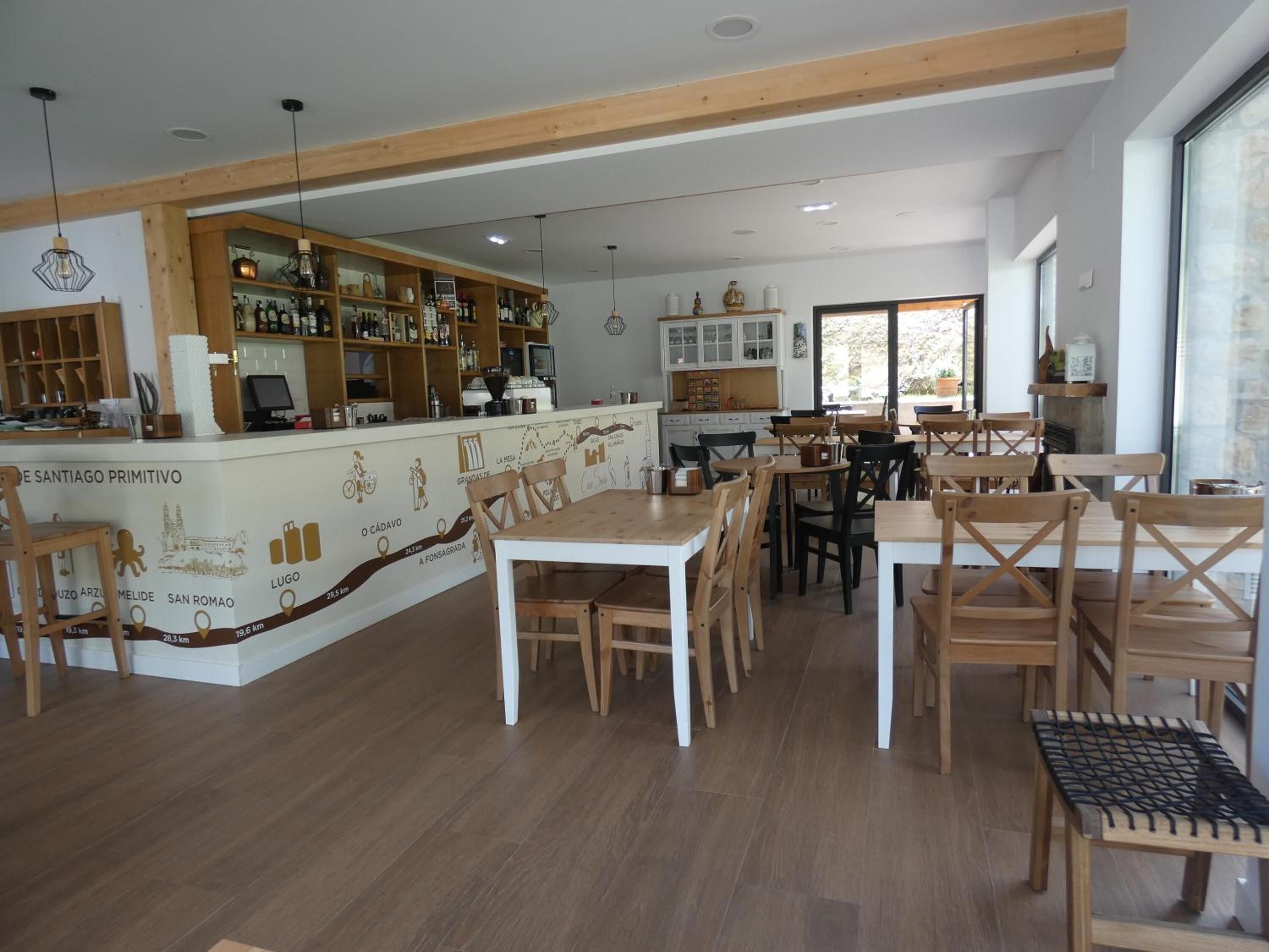 Un restaurante con mobiliario de madera, una barra con estantes llenos de botellas y una pared con un mapa.