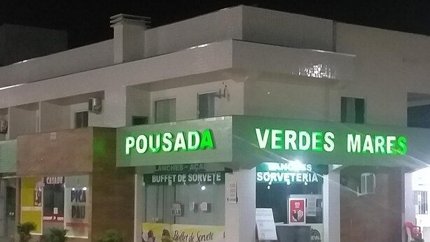 A building with storefronts labeled "POUSADA" and "VERDES MARES". - Pousada Verdes Mares (Guaratuba)