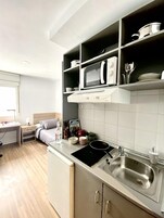 Frigorífico grande, microondas, placa de cocina y utensilios de cocina