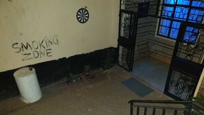 A staircase with a handrail, a trash can, and a wall with a "SMOKING ZONE" sign. - Jamhuri Home 2 (Nairobi)