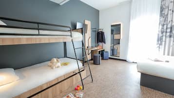 Une chambre d’hôtel moderne équipée d’un lit superposé, d’un bureau, d’un miroir et d’une fenêtre avec des rideaux.
