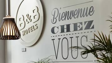 Een muur met een 'B&B'-bord en een bord met de tekst 'Bienvenue Chez Vous'.