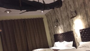 A bedroom with a large bed, a smaller bed, and a wooden headboard. - Rooming House (Greater Noida)