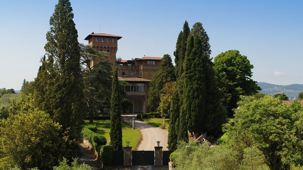 A large, historic building with a tower, surrounded by lush greenery and a well-maintained garden. - Antico Castello Marignolle (Florence)
