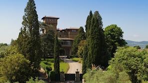 A large, historic building with a tower, surrounded by lush greenery and a well-maintained garden. - Antico Castello Marignolle (Florence)