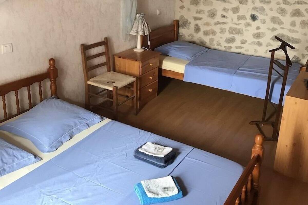 Une chambre avec deux lits, un bureau et une chaise.