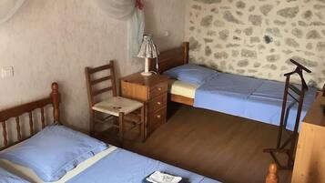 A bedroom with two beds, a desk, and a chair.