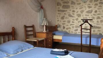 A bedroom with two beds, a desk, and a chair.