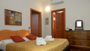 A hotel room with a large bed, wooden wardrobe, and a painting on the wall. - La Terrazza Foscolo - con Parcheggio (Florence)