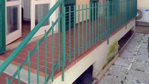 A building with a wooden balcony, green shutters, and a tiled floor. - La Terrazza Foscolo - con Parcheggio (Florence)