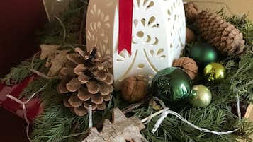 Eine Weihnachtsdekoration mit einem weißen Ei, rotem Band, Zapfen und grünen Ornamenten.