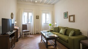 A living room with a television, a sofa, a coffee table, and a chair. - Porcellana (Florence)