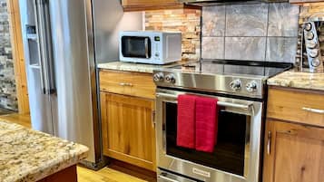 Enjoy cooking in this well-equipped kitchen with a refrigerator, microwave, oven, and coffee maker.