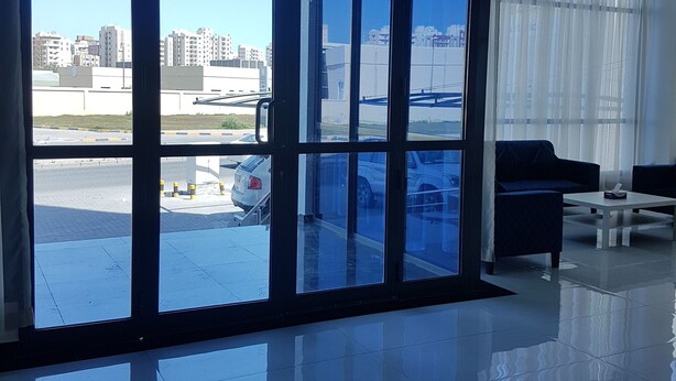 A spacious room with large windows, a modern interior, and a view of the cityscape. - Magic Suite Boulevard Salmiya (Salmiya)