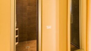 A bathroom with a shower, a mirror, and a light switch. - Piccolo Sogno (Florence)