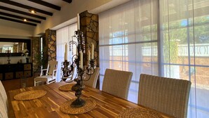 A dining area with a wooden table, woven placemats, wicker chairs, and a candelabra. - Owner Joan Andreu Calvet Fosch, Luxury villa with private pool. (Alcanar Playa)