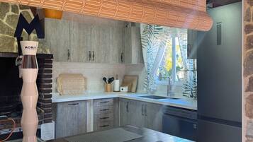 Une cuisine avec un mur en pierre, un plan de travail en bois, une machine à café Morit et une enseigne indiquant « Punta Cana ».