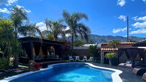 A swimming pool with a curved edge, surrounded by lounge chairs and a covered seating area. - Owner Joan Andreu Calvet Fosch, Luxury villa with private pool. (Alcanar Playa)