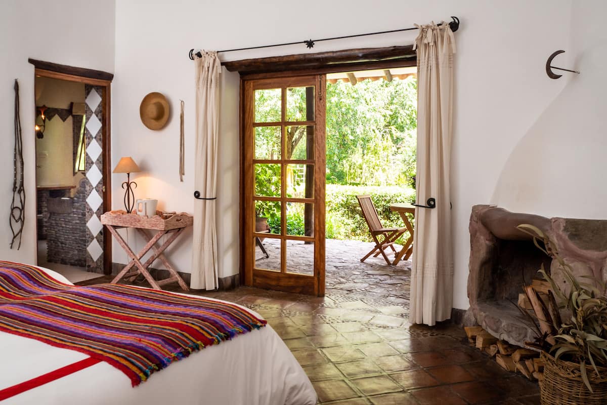 Relax in this serene retreat with a large bed, a cozy side table, and a patio area perfect for unwinding.