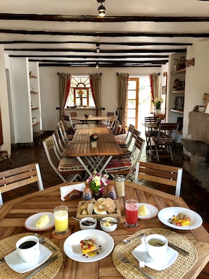 Guests can dine in style with a large table set for a meal, surrounded by comfortable chairs and a variety of dishes.