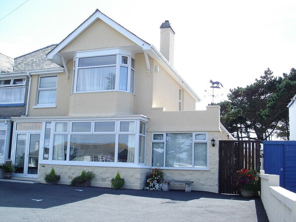 A two-story house with a bay window, a visible front door, and a blue gate. - Pensalda Guest House (Newquay)