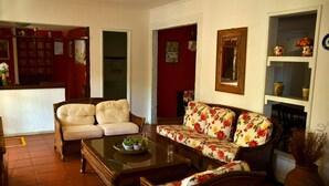 Una sala de estar con un sofá, sillones, una mesa de centro y una estantería.