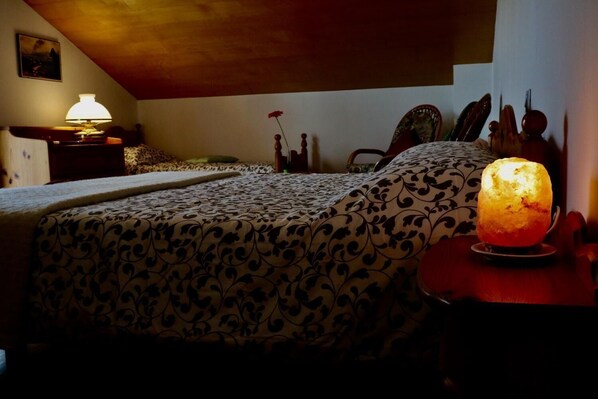 A bedroom with a bed, a nightstand, a lamp, and a decorative salt lamp. - Bed & Breakfast La Pecora Nera (Belluno)
