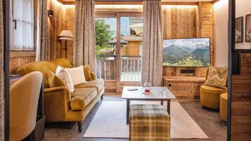 A cozy living room with a sofa, a coffee table, and a television.