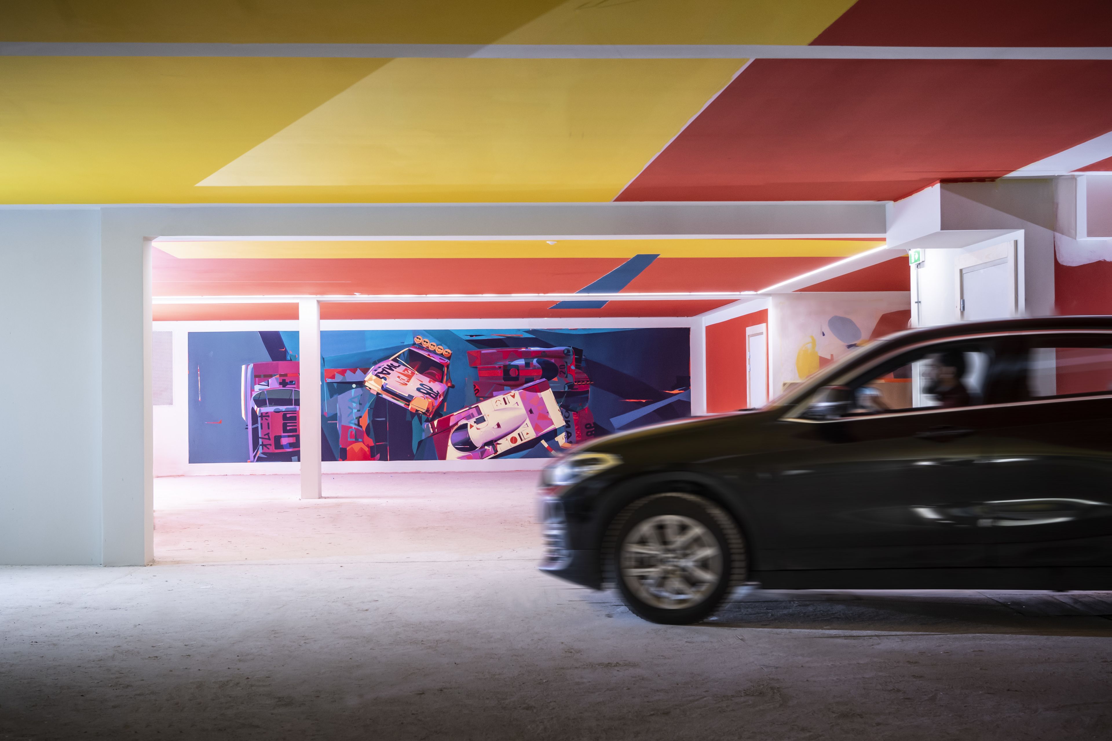 A parking garage with a colorful mural on the wall.