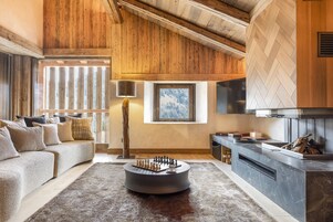 Una sala de estar acogedora con chimenea, una mesa de centro redonda y un sofá.