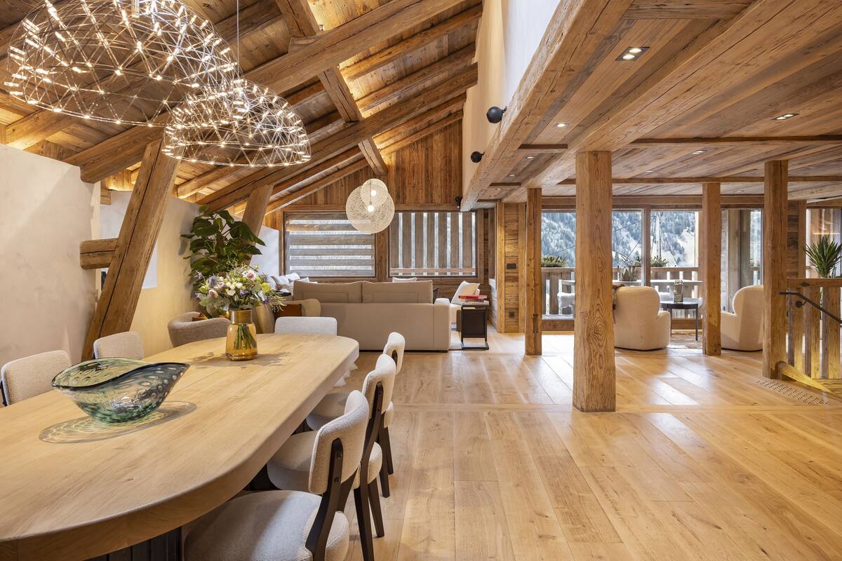 Un comedor amplio con una mesa de madera, sillas y un cuenco de vidrio decorativo.