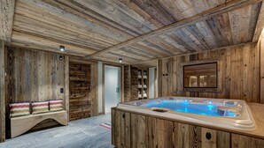 Un interno in legno con una vasca idromassaggio, panche di legno e uno scaffale a parete.