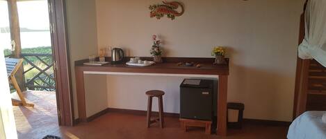 Uma pequena cozinha equipada com cafeteira, chá e um frigorífico.